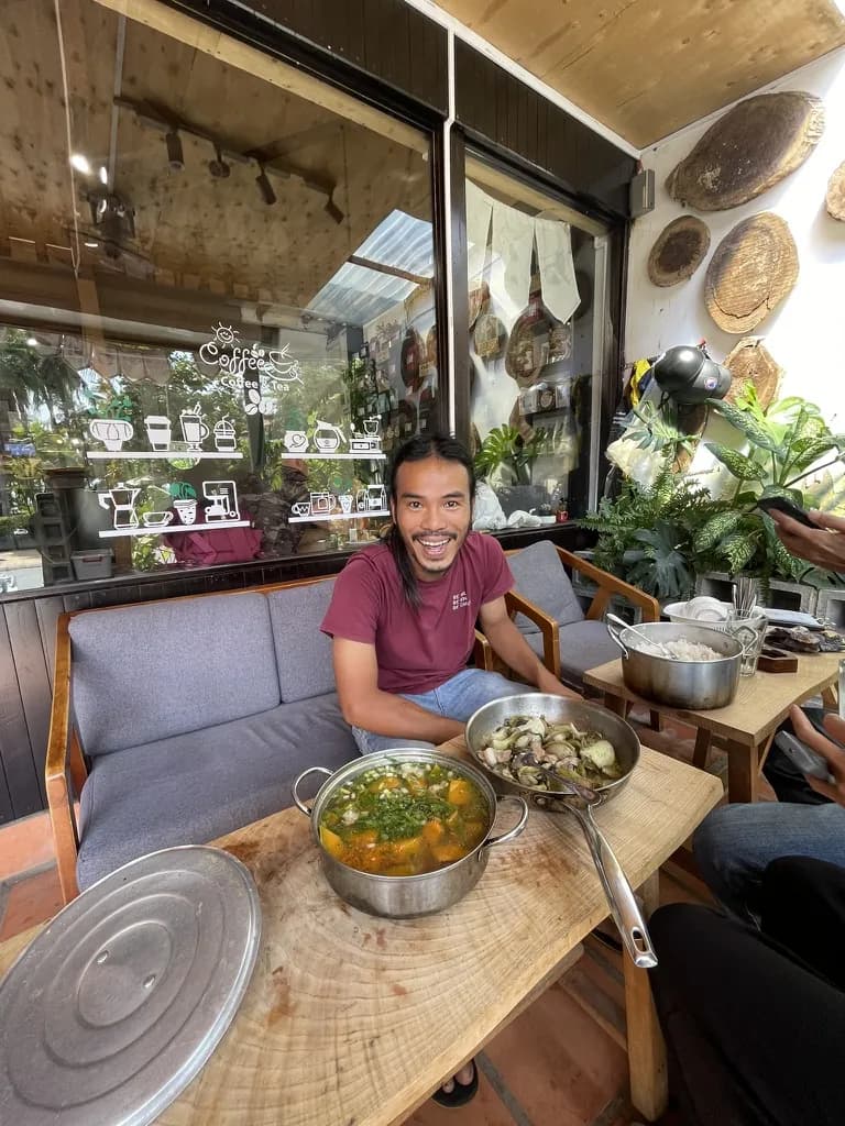 A café owner named Phúc sharing a meal during a long conversation.