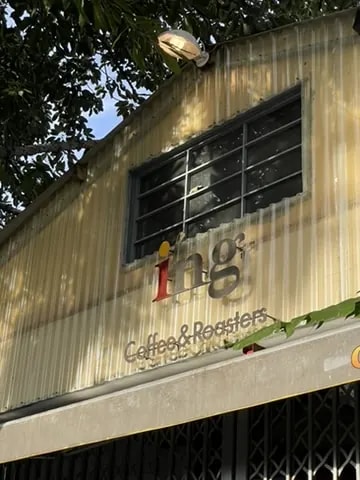The exterior sign of Ing Coffee and Roasters on a corrugated metal building.