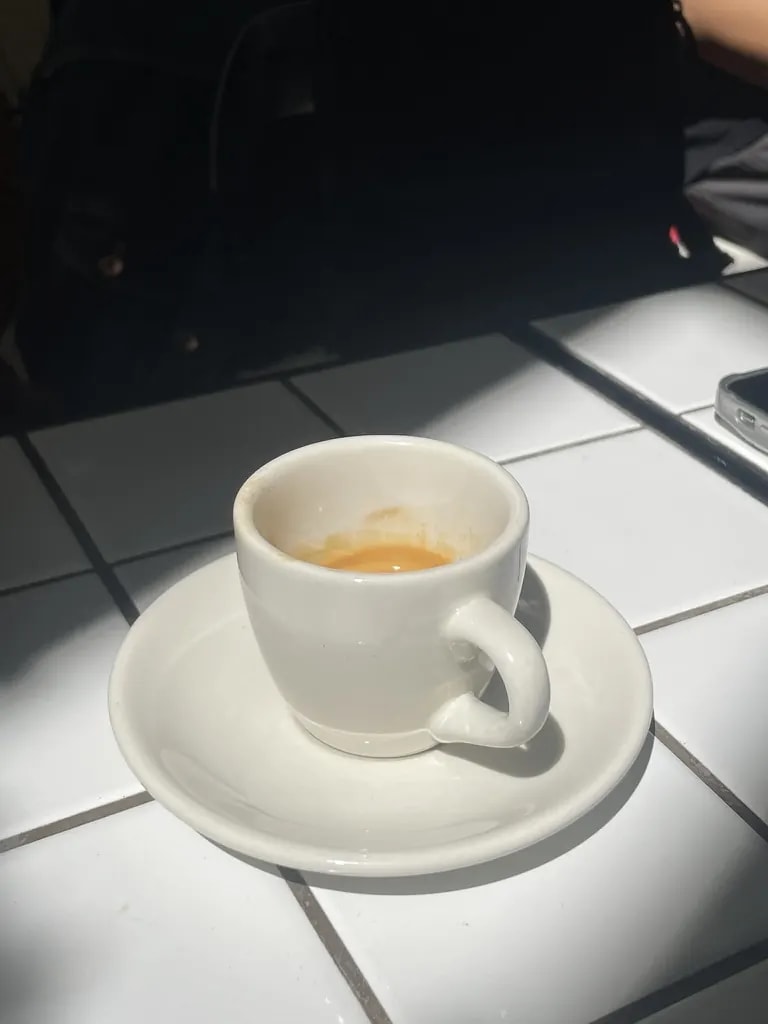 A white espresso cup in strong afternoon sunlight.
