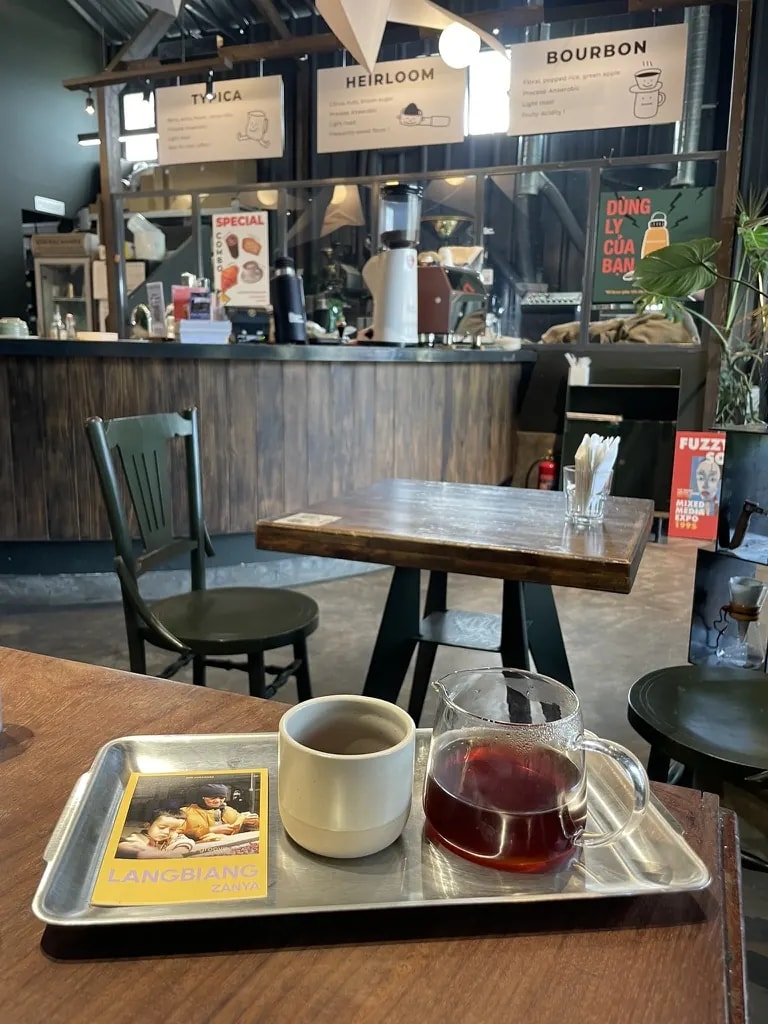 A Langbiang Zanya coffee tasting with a cup and glass carafe.
