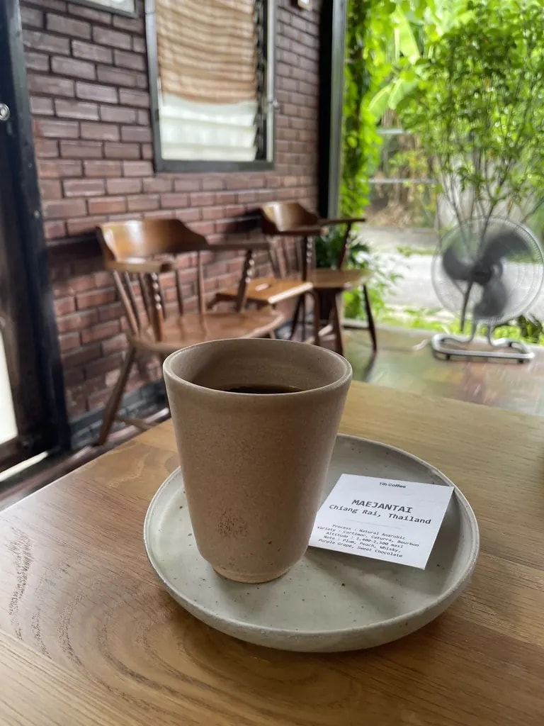 Specialty coffee served in a ceramic cup with a Mae Jantai origin card.