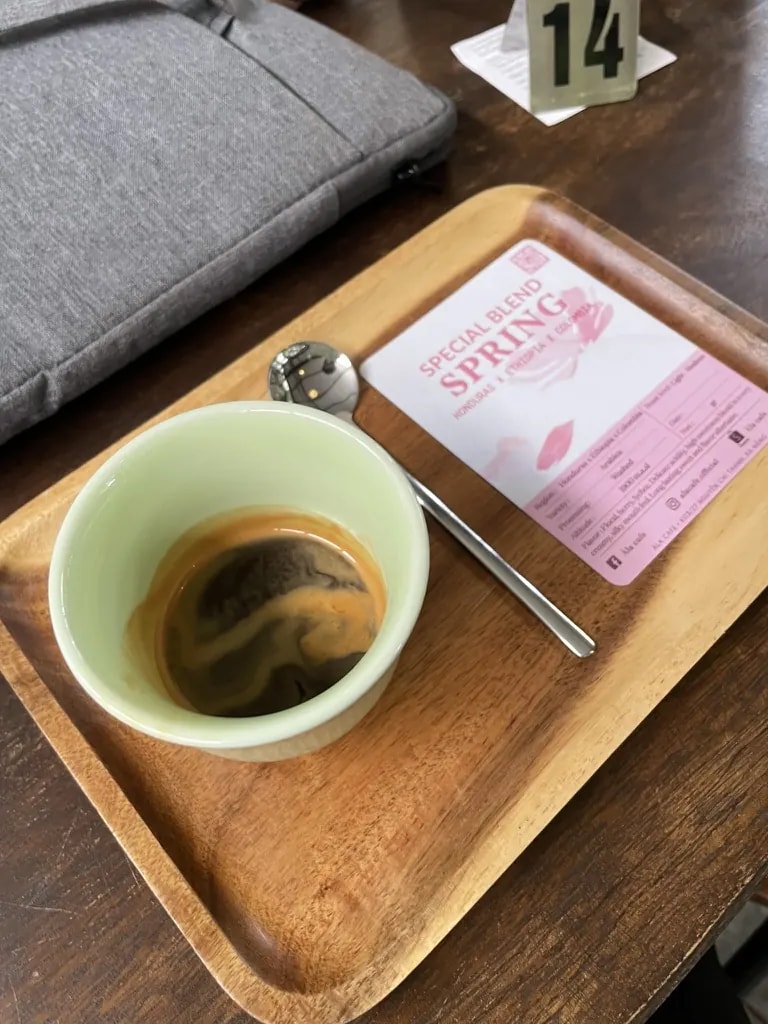 An espresso beside a pink tasting card for a special coffee blend.